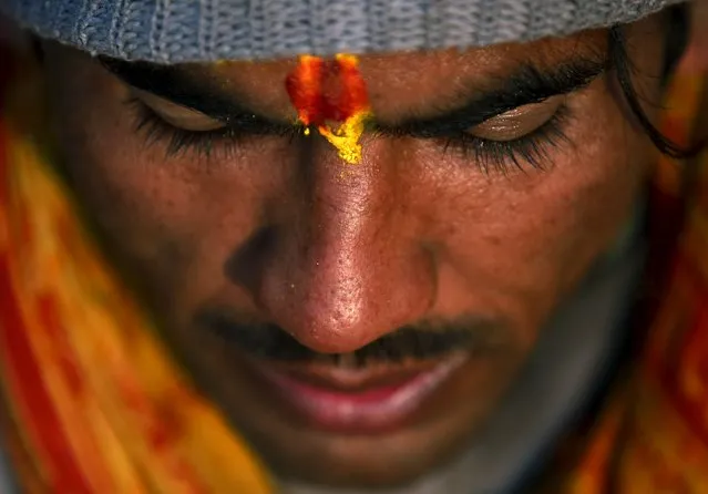 A Hindu holy man recites verses from the holy Swasthani Brata Katha book at the bank of River Saali in Sankhu during the Swasthani Brata Katha festival in Kathmandu, Nepal, January 24, 2016. (Photo by Navesh Chitrakar/Reuters)