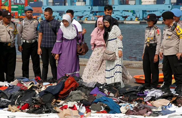 Wife (3-R) of Lion Air flight JT-610 plane crash victim Indonesian policeman Mito looks for her husband's belongings at the collection point at Tanjung Priok Harbour, Jakarta, Indonesia, 31 October 2018. Lion Air flight JT-610 lost contact with air traffic controllers soon after takeoff then crashed into the sea. The flight was en route to Pangkal Pinang, and reportedly had 189 people onboard. (Photo by Adi Weda/EPA/EFE)