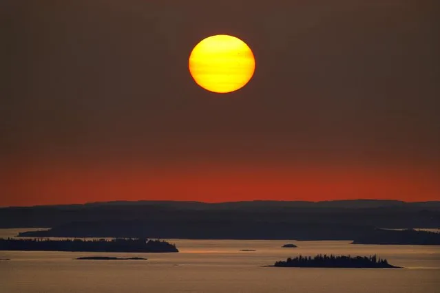 The sun rises over Maine's Penobscot Bay, Wednesday, September 27, 2023. Researchers with the National Oceanic and Atmospheric Administration say marine mammals are vulnerable to a variety of threats such as loss of habitat and food due to the consequences of warming waters. (Photo by Robert F. Bukaty/AP Photo)