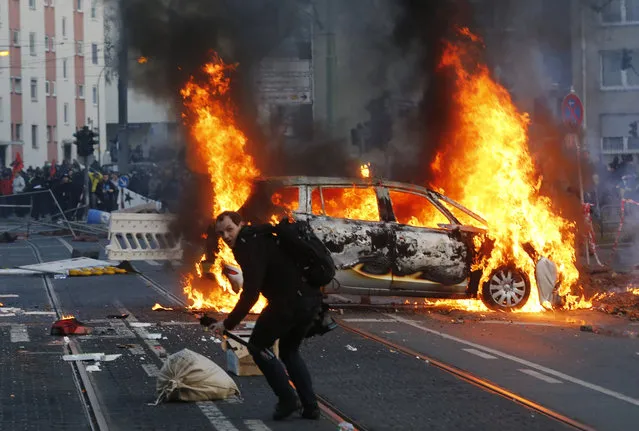 A police car burns after clashes between demonstrators and police Wednesday, March 18, 2015 in Frankfurt, Germany. (Photo by Michael Probst/AP Photo)