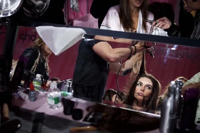 Hilary Rhoda has her hair done backstage before the taping of the 2013 Victoria's Secret Fashion Show. (Photo by Carlo Allegri/Reuters)