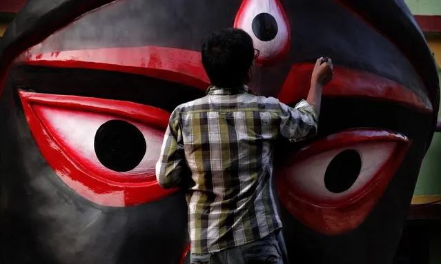 An artist paints a giant fiber-made face of a hundred-foot-tall icon of the Hindu goddess Kali made by Krishanu Pal near a workshop ahead of the Diwali festival in Kolkata, eastern India, 06 November 2023. Diwali, the festival of lights, symbolizes the victory of good over evil and commemorates Lord Ram's return to his kingdom, Ayodhya, after completing a 14-year exile. This year, Diwali will be celebrated across the country on 12 November, on the same day as Kali Puja, which is dedicated to the Hindu goddess Kali. (Photo by Piyal Adhikary/EPA)