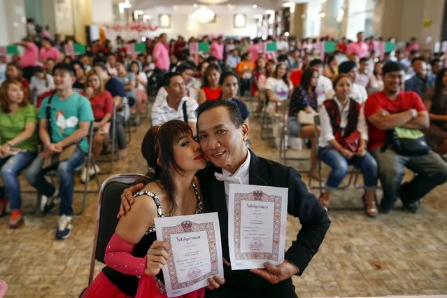 Groom Sakda Kulpanish, 58 and his bride Chongchit Chomworapong, 56, pose with certificate during a Valentine's Day celebration at the Bangrak district in Bangkok, Thailand, February 14, 2016. (Photo by Athit Perawongmetha/Reuters)
