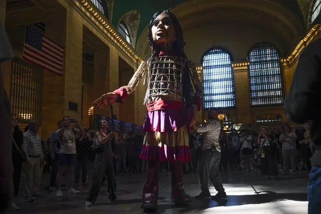 A large puppet named Little Amal walks around Grand Central Station in New York, Thursday, September 15, 2022. New York City's latest celebrity visitor is stopping traffic even in this jaded, larger-than-life town. Little Amal, a 12-foot puppet of a 10-year-old Syrian refugee, is on a 17-day blitz through every corner of the Big Apple as part of a theater project hoping to raise awareness about immigration. (Photo by Seth Wenig/AP Photo)