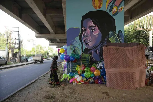 A nomadic woman who sell balloons and toys prepares to start her day under a flyover in Jammu, India, Tuesday, September 26, 2023. (Photo by Channi Anand/AP Photo)