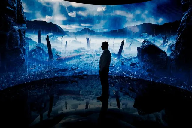A man looks at a digital display at an exhibition by the Andrey Melnichenko Foundation during the COP28 United Nations climate summit in Dubai on December 1, 2023. World leaders take centre stage at UN climate talks in Dubai on December 1, under pressure to step up efforts to limit global warming as the Israel-Hamas conflict casts a shadow over the summit. (Photo by Ludovic Marin/AFP Photo)