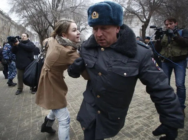 Police officers detain people who gathered for an unsanctioned event in downtown Volgograd, Russia, Monday, December 30, 2013. A bomb blast tore through a trolleybus in the city of Volgograd on Monday morning, killing at least 10 people. a day after a suicide bombing that killed at least 17 at the city's main railway station. Volgograd is about 650 kilometers (400 miles) northeast of Sochi, where the Olympics are to be held. (Photo by Denis Tyrin/AP Photo)