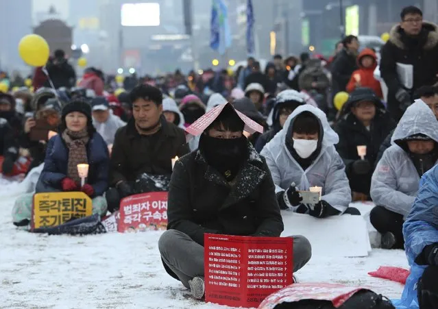 Protesters attend a candle light vigil calling for impeached President Park Geun-hye to step down in Seoul, South Korea, Saturday, January 21, 2017. South Korean prosecutors on Saturday arrested Park's culture minister and her former top presidential adviser over allegations that they blacklisted artists critical of the government. (Photo by Ahn Young-joon/AP Photo)