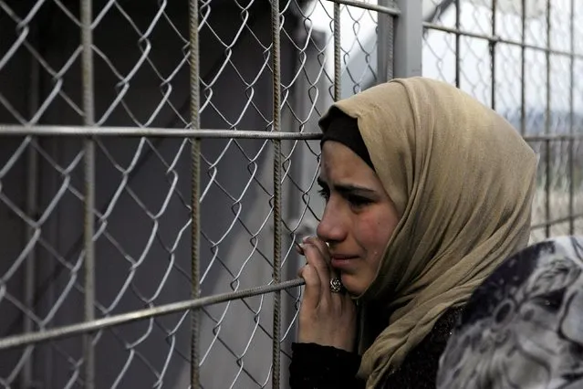 A refugee cries next to the border fence of the Greek-Macedonian borderas  during a protest by stranded refugees who wait for the border crossing to reopen near the Greek village of Idomeni, February 28, 2016. (Photo by Alexandros Avramidis/Reuters)