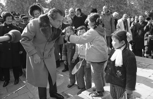 Then First lady Pat Nixon watches behind him, then U.S. President Richard Nixon shakes hands with a Chinese girl in Beijing on February 24, 1972 during his tour of historic sites of the Chinese capital. At the height of the Cold War, U.S. President Richard Nixon flew into communist China's center of power for a visit that over time would transform U.S.-China relations and China's position in the world in ways that were unimaginable at the time. (Photo by AP Photo, File)