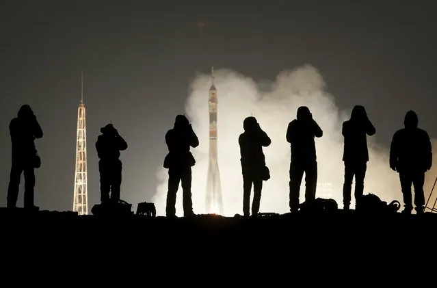 Photographers take pictures as the Soyuz TMA-20M spacecraft carrying the crew of Jeff Williams of the U.S., Alexey Ovchinin and Oleg Skripochka of Russia blasts off to the International Space Station (ISS) from the launchpad at the Baikonur cosmodrome, Kazakhstan, March 19, 2016. (Photo by Shamil Zhumatov/Reuters)