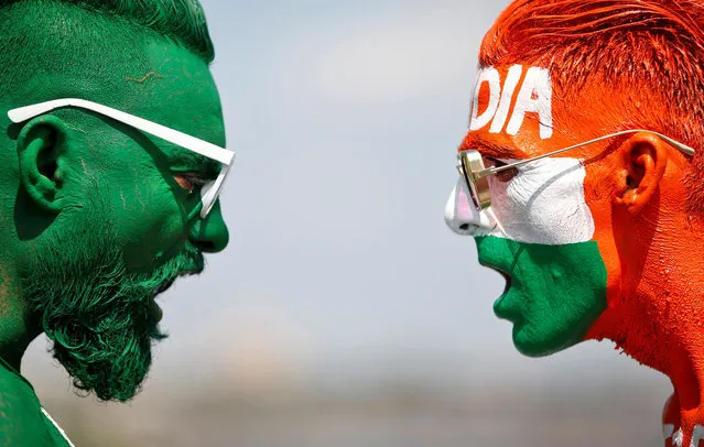 Cricket fans, with their faces painted in the Indian and Pakistani national flag colours, pose for a picture ahead of the first match between India and Pakistan in Twenty20 World Cup super 12 stage in Dubai, in Ahmedabad, India, October 23, 2021. (Photo by Amit Dave/Reuters)