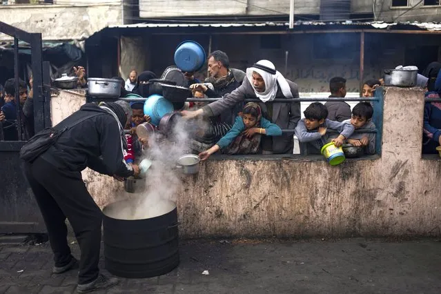 Palestinians line up for a free meal in Rafah, Gaza Strip, Friday, February 16, 2024. International aid agencies say Gaza is suffering from shortages of food, medicine and other basic supplies as a result of the war between Israel and Hamas. (Photo by Fatima Shbair/AP Photo)
