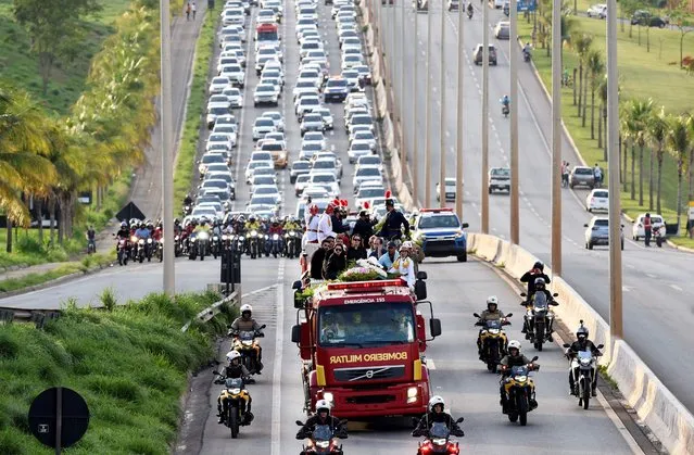 A military firefighter brigade truck carrying the remains of Brazilian singer Marilia Mendonca leads the funeral cortege to the Cementerio Parque Memorial, in Goiania, state of Goias, Brazil, on November 6, 2021. Marilia Mendonca, 26, one of the most popular of the “sertanejo” genre in Brazil and a Latin Grammy winner, died on the eve along with four other people in an airplane crash on her way to a concert, in the state of Minas Gerais. (Photo by Evaristo Sa/AFP Photo)