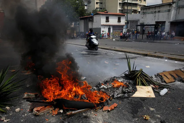 A fire barricade burns at a protest against the government of Venezuelan President Nicolas Maduro in Caracas, Venezuela March 31, 2019. (Photo by Carlos Garcia Rawlins/Reuters)