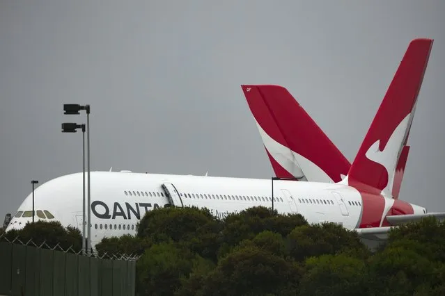 In this June 25, 2020, file photo, two Qantas planes sit outside its hangar at the Los Angeles International Airport in Los Angeles. Qantas, Australia's largest airline, announced Thursday, Aug. 26, 2021, it has posted a 2.35 billion Australia dollar ($1.7 billion) pandemic-related annual loss and forecast Australia will be reopen to international travel in December. (Photo by Jae C. Hong/AP Photo/File)