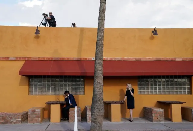 U.S. President Joe Biden’s director of speech writing Vinay Reddy works at his laptop and White House economic advisor Lael Brainard talks on her phone as members of the Secret Service keep watch atop a Mexican restaurant where Biden was holding a campaign event in Phoenix, Arizona, U.S., March 19, 2024. (Photo by Kevin Lamarque/Reuters)