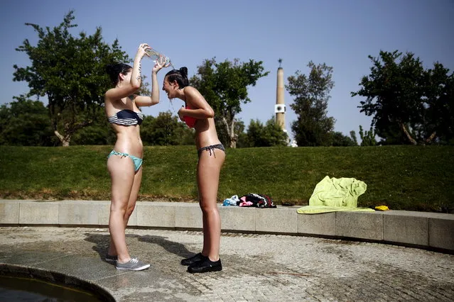 Jennifer Perez, 19, pours water on her friend Marijose Sanchez, 19, as they try to cool off while sunbathing during a hot spring day in Madrid, Spain, May 12, 2015. Temperatures will rise up to 40 degrees Celsius (104 fahrenheit) in some parts of Spain, the Spanish Agency of Meteorology (AEMET) said on Tuesday. (Photo by Susana Vera/Reuters)
