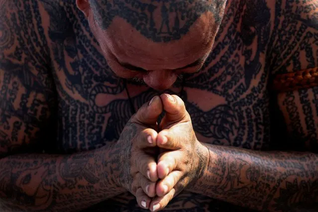 A devotee prays as he attends the religious tattoo festival at Wat Bang Phra Monastery, where devotees believe that their tattoos have mystical powers, in Nakhon Pathom province, Thailand, on March 23, 2024. (Photo by Chalinee Thirasupa/Reuters)