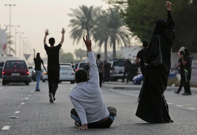 Bahraini Shiite Muslim protesters confront riot police blocking the path of their protest march during a demonstration denouncing a suicide bombing at a Shiite mosque in Saudi Arabia, in Daih, Bahrain, Saturday, May 23, 2015. The unauthorized protest was dispersed by riot police firing tear gas and birdshot. The Islamic State group claimed responsibility for the Saudi mosque bombing that killed and wounded many people. (Photo by Hasan Jamali/AP Photo)