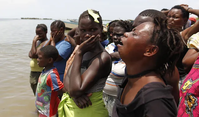 Relatives and friends mourn as the bodies of people killed after a boat carrying mostly Congolese refugees capsized at the shores of Lake Albert are brought to the landing zone in Ntoroko district in Western Uganda, March 24, 2014. (Photo by Thomas Mukoya/Reuters)
