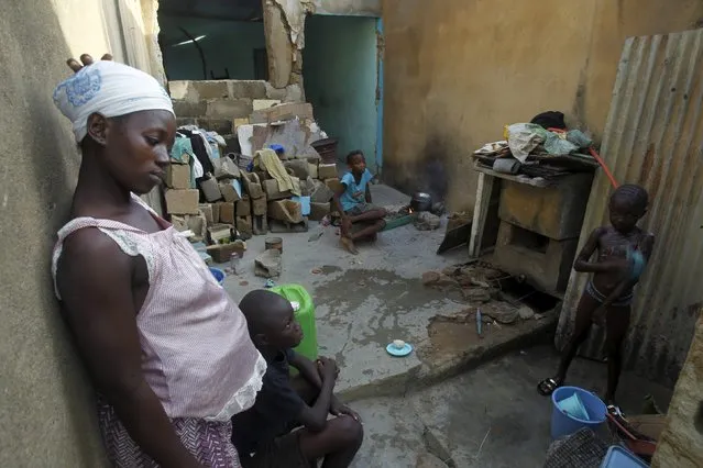 Outtara Sandrine (L), 23, stands near a bathing child at her home in the Cocody Danga slum in Abidjan, Cote D'Ivoire May 25, 2015. (Photo by Luc Gnago/Reuters)