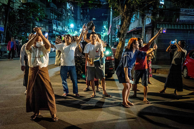 In this photo taken on February 3, 2021 people take part in a noise campaign on the street after calls for protest went out on social media in Yangon as Myanmar's ousted leader Aung San Suu Kyi was formally charged on Wednesday two days after she was detained in a military coup. (Photo by AFP Photo/Stringer)