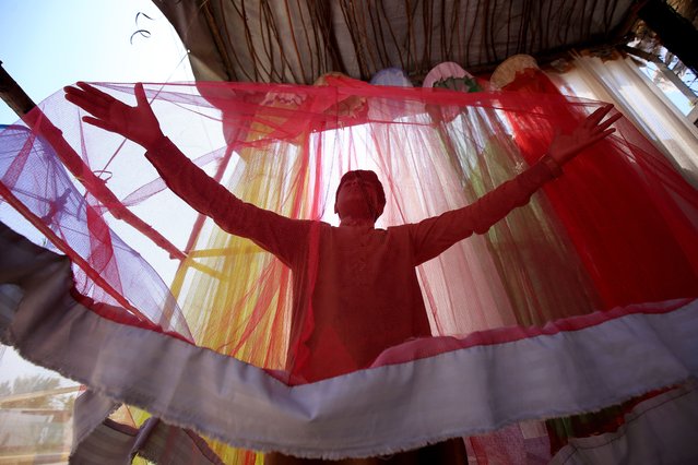 A boy waits for customers as he sells mosquito nets on the roadside during World Malaria Day in Peshawar, Pakistan, 25 April 2024. World Malaria Day is observed every year on 25 April to raise global awareness of efforts to combat malaria and promote the reduction of suffering and deaths from the disease. The theme for World Malaria Day 2024 is “Accelerating the fight against malaria for a more equitable world”. (Photo by Bilawal Arbab/EPA/EFE)