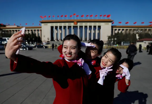 Hotel guides pose in front of the Great Hall of the People at the Tiananmen Square during a plenary session of the National People's Congress (NPC) in Beijing, China, March 12, 2017. (Photo by Damir Sagolj/Reuters)