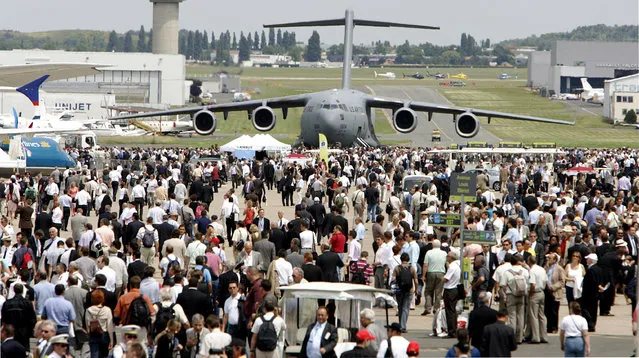 FILE - This June 17, 2009 file photo shows a US Air Force Boeing-made Globe Master III  in background as visitors crowd the tarmac, at Le Bourget, north of Paris, during the 48th Paris Air Show. Just eight miles from the center of Paris, the normally sleepy aerodrome in Le Bourget will undergo its biennial transformation into the center of the world's $700 billion aerospace and defense industry when it hosts the 51st International Paris Air Show from June 15 to June 21. (AP Photo/Remy de la Mauviniere/File)