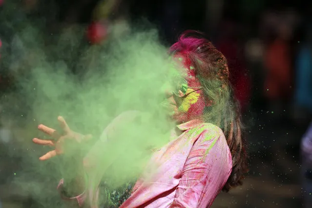 A Bangladeshi woman reacts as colored powder is thrown on her face during celebrations marking Holi, the Hindu festival of colors, in Dhaka, Bangladesh, Monday, March 13, 2017. (Photo by A.M. Ahad/AP Photo)