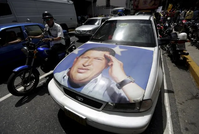 A car with the image of Venezuela's late President Hugo Chavez are see before a demonstration of union members of Empresas Polar's beer factory in Caracas, July 2, 2015. (Photo by Jorge Dan Lopez/Reuters)