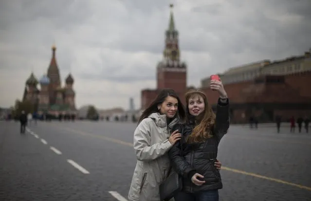 In this Monday, October 6, 2014 file photo, two young women pose for a selfie on Red Square with St. Basil's Cathedral, left, and the Spasskaya Tower, right in Moscow, Russia. Alarmed by the number of Russians who have been killed while taking photos of themselves with smartphones, Russian police have started a new campaign called “Safe Selfies”. (Photo by Alexander Zemlianichenko/AP Photo)