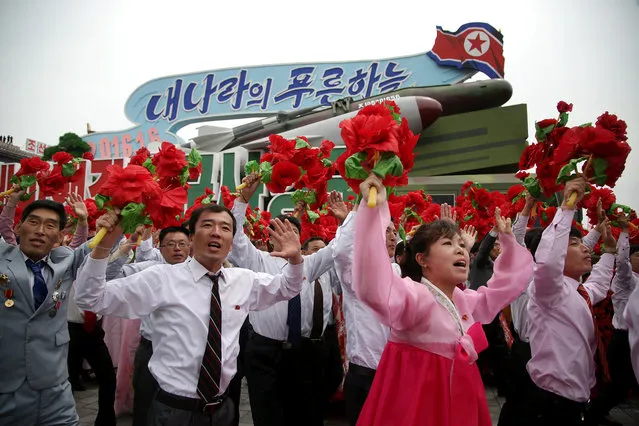 North Korean parade participants wave decorative bouquets of flowers and carry their country's national flag as they march with different types of models of missiles at the Kim Il Sung Square on Tuesday, May 10, 2016, in Pyongyang, North Korea. (Photo by Wong Maye-E/AP Photo)