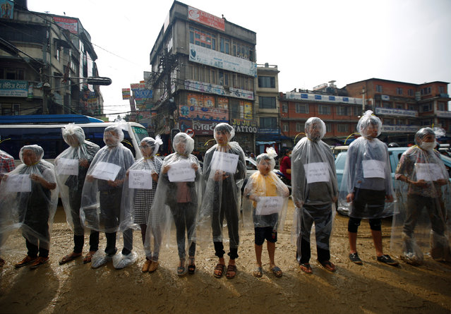 Activists take part in a demonstration to mark Earth Day by covering themselves in plastic sheets to protest against air pollution and muddy roads caused by what they say is a road expansion project in Kathmandu, Nepal April 22, 2017. (Photo by Navesh Chitrakar/Reuters)
