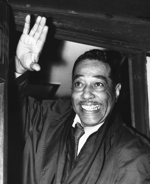 Duke Ellington waves to fans on arrival at London's Paddington Station, October 3, 1958 after traveling from Plymouth on the boat train from the S.S. Ill Del France. He is scheduled to play his first concert of his forthcoming tour at the Royal Festival Hall, London on October 5. (Photo by AP Photo)