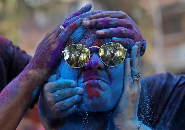 A woman reacts as coloured powder is applied on her face during Holi celebrations in Mumbai, India, March 18, 2022. (Photo by Niharika Kulkarni/Reuters)