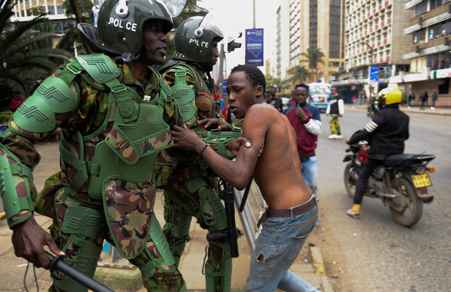 A riot police officer attempts to detain a protestor during an anti-government demonstration, following nationwide deadly riots over tax hikes and a controversial now-withdrawn finance bill, in Nairobi, Kenya, on July 16, 2024. (Photo by John Muchucha/Reuters)