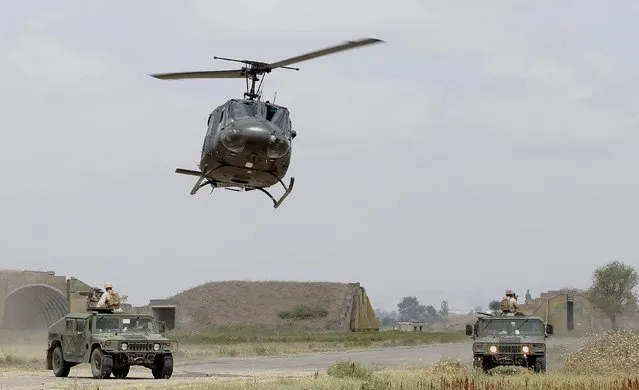 Georgian medevac helicopter flies over US marine Humvees during in a joint military exercise with NATO members, called “Agile Spirit 2015” at the Vaziani military base outside Tbilisi, Georgia, July 21, 2015. (Photo by David Mdzinarishvili/Reuters)
