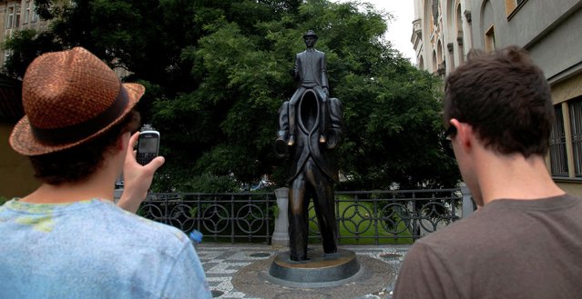 Tourists look at a statue of famous German-language writer Franz Kafka in central Prague July 3, 2013, on the day marking the 130th anniversary of his birth in Prague. (Photo by Petr Josek Snr/Reuters)