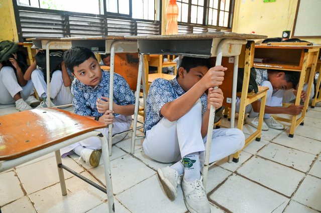 Junior high school students take cover during an earthquake and tsunami drill as part of a disaster education programme in Banda Aceh on August 7, 2024. (Photo by Chaideer Mahyuddin/AFP Photo)