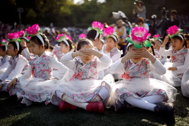 Children wearing a lantern headband rest before a Lotus Lantern parade in celebration of the upcoming birthday of Buddha in Seoul, South Korea on April 29, 2017. (Photo by Kim Hong-Ji/Reuters)