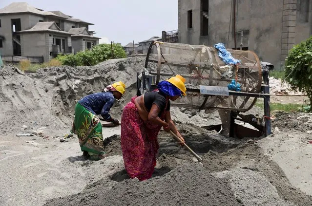 Labourers work at a construction site on a hot summer day in Noida, India, May 12, 2022. (Photo by Anushree Fadnavis/Reuters)