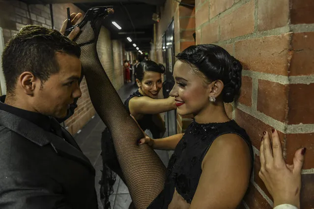 Dancers are warming up backstage during the Tango Dancing Tournament at the XIII International Tango Festival in Medellin, Colombia, on June 18, 2019. The Tango Festival takes place between the 16th and 24th of June. (Photo by Joaquin Sarmiento/AFP Photo)