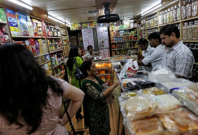People shop inside a grocery store at a residential area in Mumbai, India June 13, 2016. (Photo by Danish Siddiqui/Reuters)