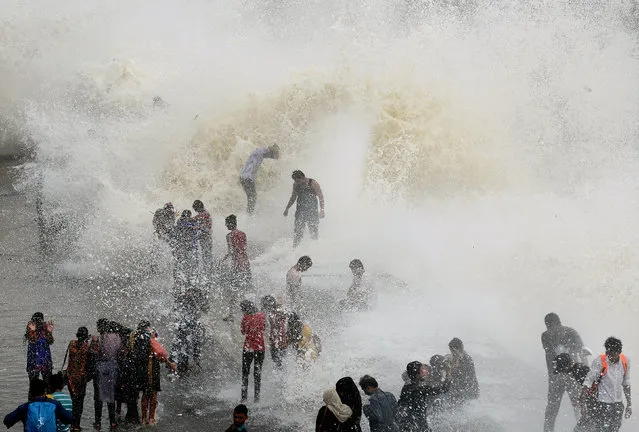 People gather by the Marine Drive seafront to be hit by breaking waves at high tide in Mumbai on June 28, 2017. (Photo by Punit Paranjpe/AFP Photo)