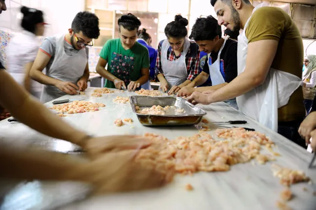 Youth, who are members of Saaed group, prepare food to be given out as Iftar meals for the poor and internally displaced Syrians during the month of Ramadan in Damascus, Syria June 18, 2016. (Photo by Omar Sanadiki/Reuters)