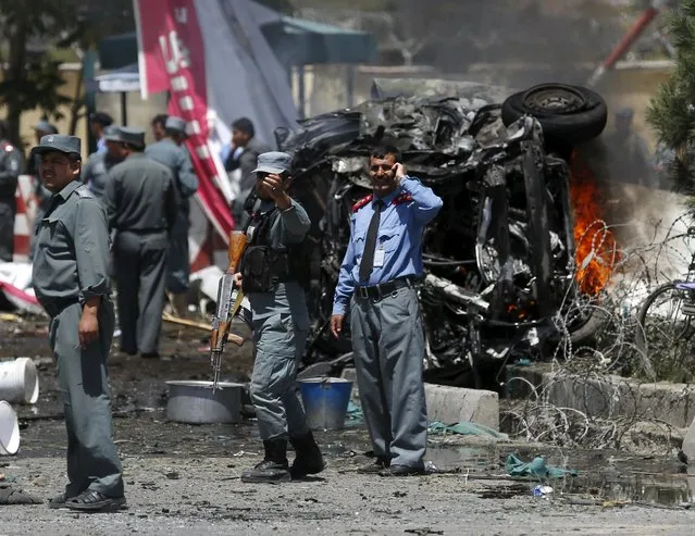 Policemen stand at the site of a car bomb blast at the entrance gate to the Kabul airport in Afghanistan August 10, 2015. A car bomb exploded near the entrance to Kabul airport and casualties are feared, officials said on Monday, days after series of suicide attacks in the Afghan capital killed dozens and wounded hundreds. (Photo by Ahmad Masood/Reuters)