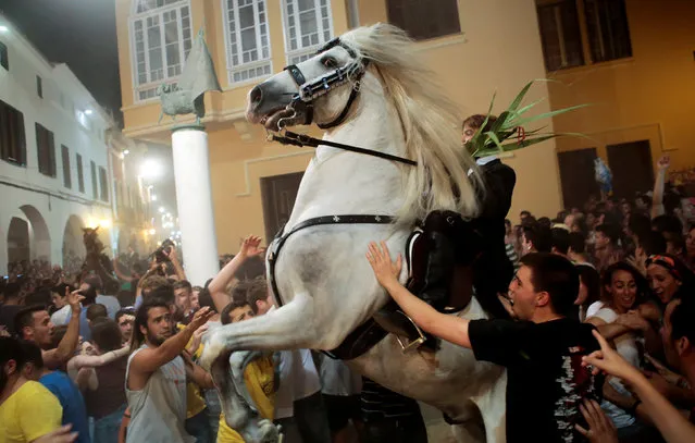 A rider rears up on his horse while surrounded by a cheering crowd during the traditional Fiesta of Sant Joan (Saint John) in downtown Ciutadella, on the island of Menorca, Spain June 23, 2016. (Photo by Enrique Calvo/Reuters)