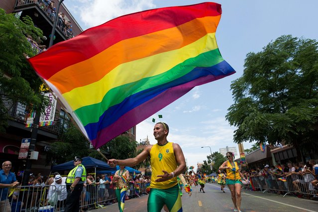 Luis Sobrinho waves a pride flag as he marches in the 47th annual Chicago Pride Parade on Sunday, June 26, 2016. (Photo by Lou Foglia/Chicago Sun-Times via AP Photo)